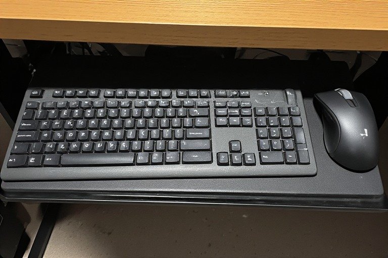 Desk with under-desk keyboard tray for clean surface