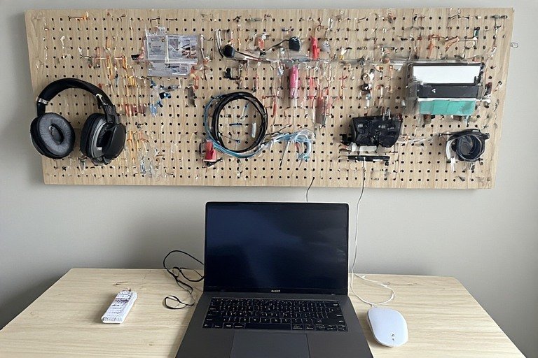 Laptop desk setup with pegboard wall organization