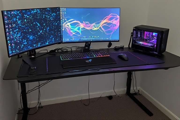 Professional gaming desk setup with dual monitors, RGB lighting, and cable management