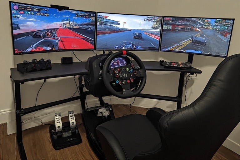 Triple monitor racing sim setup with racing wheel and pedals