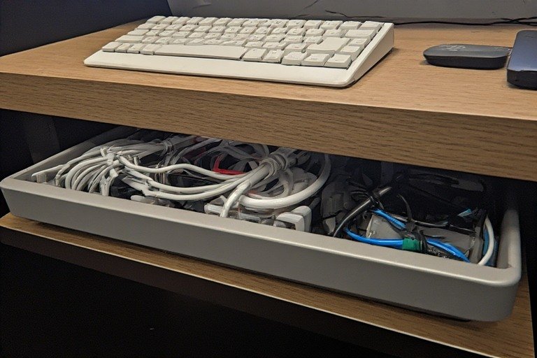 Under-desk cable tray with organized bundled cables and wireless keyboard setup