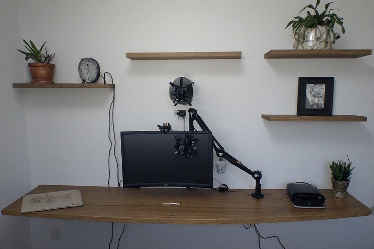 Wall-mounted floating desk with monitor arm and floating shelves