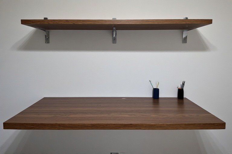 Wall-mounted floating desk with shelf above and clean minimal aesthetic