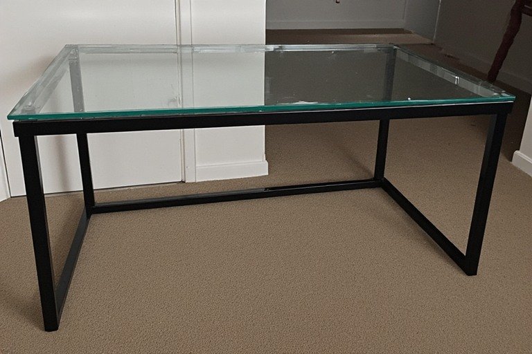 A transparent glass desktop with a black or silver metal frame is the ultimate minimal statement